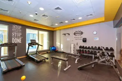 a gym with treadmills and cardio machines in a room at Luxe 1BR Hamilton Residency Business Bay with balcony in Dubai