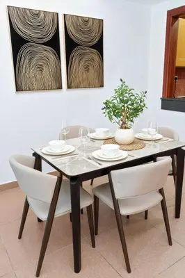 a dining room with a table and white chairs at Luxe 1BR Hamilton Residency Business Bay with balcony in Dubai