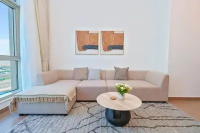 a living room with a couch and a table at Luxe 1BR Hamilton Residency Business Bay with balcony in Dubai
