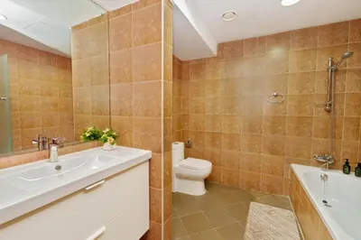 a bathroom with a tub and a toilet and a sink at Luxe 1BR Hamilton Residency Business Bay with balcony in Dubai