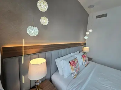 a small bedroom with a bed with a lamp and two pillows at Highend Luxury 2BR Direct Burj Khalifa & Fountain Views in Dubai