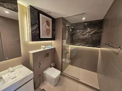 a bathroom with a shower and a toilet and a sink at Highend Luxury 2BR Direct Burj Khalifa & Fountain Views in Dubai