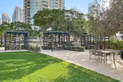 a patio with tables and chairs in a park at Downtown Luxury Two Bedroom Apartment I Conntected To Dubai Mall And Metro I Steps Away From Burj Khalifa I by Luxury Space in Dubai