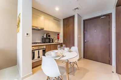 a kitchen and dining room with a table and chairs at Canal View, Easy Downtown Access, Reva Residences, Business Bay by Deluxe Holiday Homes in Dubai