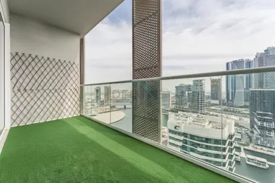 a balcony with green flooring and a view of a city at Canal View, Easy Downtown Access, Reva Residences, Business Bay by Deluxe Holiday Homes in Dubai