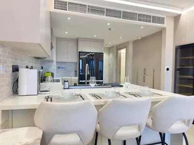 a kitchen with a table with white chairs and a counter at Unique Sea View 1BDR Apartment | Anantara Palm in Dubai