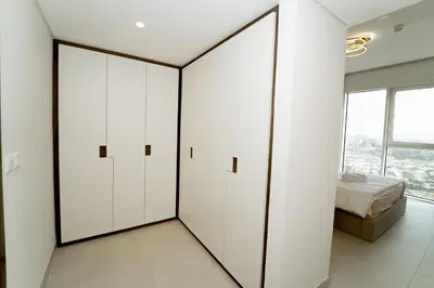 a bedroom with white cabinets and a bed at Luxury 2BR in Al Kifaf with Frame View, Near Trade Center, Metro Access in Dubai