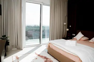 a bedroom with a bed and a large window at Luxury 2BR in Al Kifaf with Frame View, Near Trade Center, Metro Access in Dubai