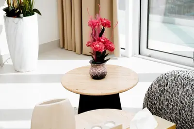 a vase with flowers on a table in a room at Luxury 2BR in Al Kifaf with Frame View, Near Trade Center, Metro Access in Dubai