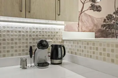 a kitchen counter with a coffeemaker and a coffee maker at Infinity Pool & Private Beach 1BR Palm Jumeirah in Dubai