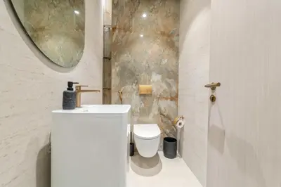 a bathroom with a toilet and a sink and a mirror at VayK - Bright and Modern One Bedroom in JVC in Dubai