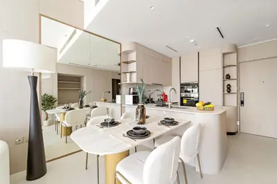 a kitchen and dining room with white tables and chairs at VayK - Bright and Modern One Bedroom in JVC in Dubai