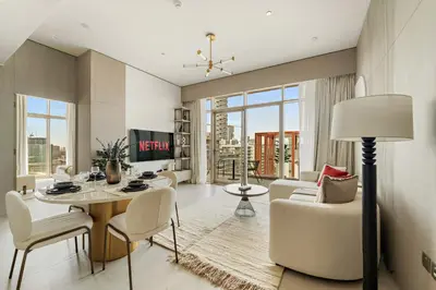 a living room with a table and chairs at VayK - Contemporary One Bedroom Apartment in JVC in Dubai