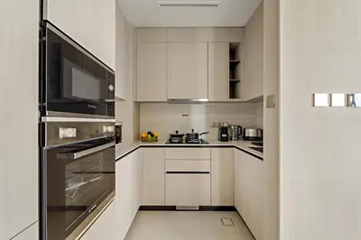 a kitchen with white cabinets and stainless steel appliances at VayK - Contemporary One Bedroom Apartment in JVC in Dubai