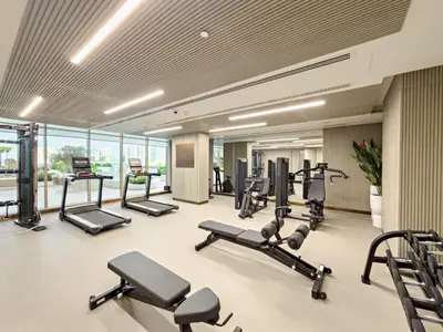 a gym with several treadmills and cardio machines at VayK - Contemporary One Bedroom Apartment in JVC in Dubai