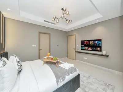 a bedroom with a bed and a tv on the wall at Aurora - 2BR Paramount Hotel Midtown Dubai, Skyline & Burj Khalifa View in Dubai