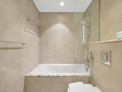 a bathroom with a shower and a bath tub at Aurora - 2BR Paramount Hotel Midtown Dubai, Skyline & Burj Khalifa View in Dubai