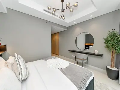 a bedroom with a white bed and a mirror at Aurora - 2BR Paramount Hotel Midtown Dubai, Skyline & Burj Khalifa View in Dubai