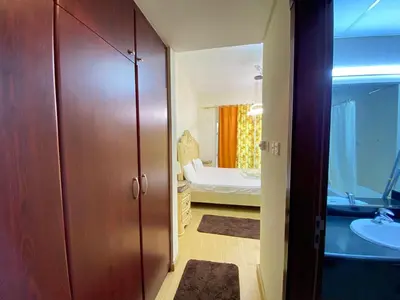 a bathroom with a closet and a bedroom with a bed at Studio in discovery garden Near gardens metro station in Dubai