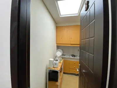 a kitchen with wooden cabinets and a skylight at Studio in discovery garden Near gardens metro station in Dubai