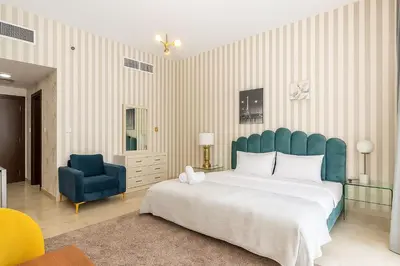 a bedroom with a large bed and a blue chair at Cloud 9 Room Marina in Dubai