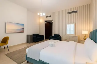 a bedroom with a large white bed and two chairs at Cloud 9 Room Marina in Dubai