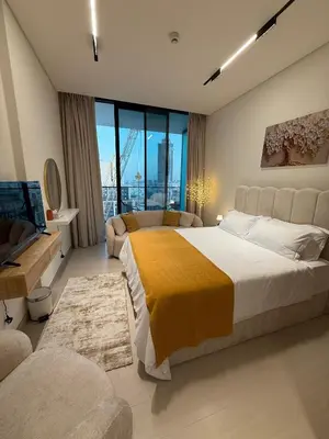 a bedroom with a large bed and a large window at Modern Studio Apartment In JVC in Dubai