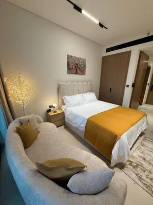 a bedroom with a large bed and a couch at Modern Studio Apartment In JVC in Dubai