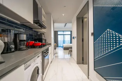 a kitchen with a washer and dryer in a room at Luxury Downtown Studio Pool Marina View in Dubai