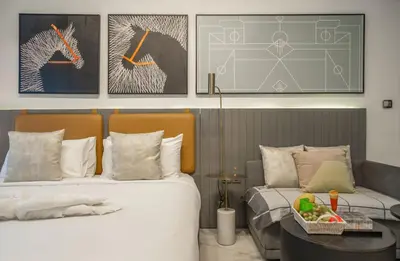 a bedroom with two beds and a table and pictures at Luxury Downtown Studio Pool Marina View in Dubai