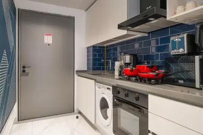 a kitchen with a washing machine and red appliances at Luxury Downtown Studio Pool Marina View in Dubai