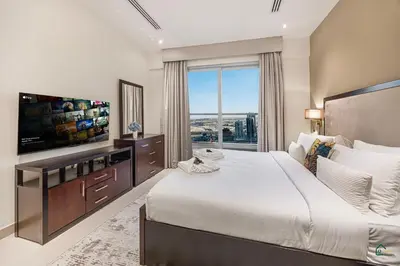 a bedroom with a large bed and a large window at Spacious & cozy Studio in Downtown! in Sabkhah