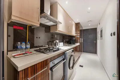 a kitchen with wooden cabinets and a stove top oven at Spacious & cozy Studio in Downtown! in Sabkhah