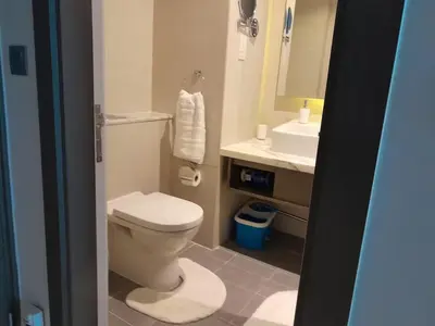 a bathroom with a toilet and a sink and a mirror at Bright and Modern 1-Bed Studio with Sofa in DAMAC Prive in Dubai