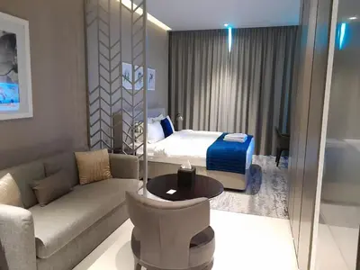 a hotel room with a bed and a couch at Bright and Modern 1-Bed Studio with Sofa in DAMAC Prive in Dubai