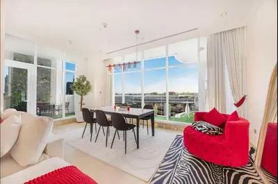 a living room with a red chair and a table at FiveX Premium 2BR at Trident Waterfront Marina in Dubai