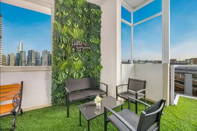 a balcony with chairs and a green wall at FiveX Premium 2BR at Trident Waterfront Marina in Dubai