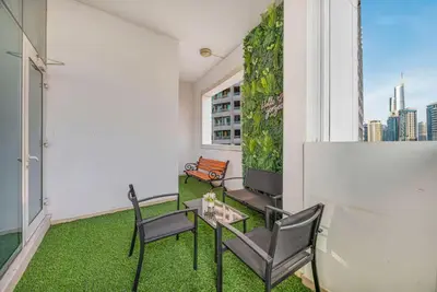 a balcony with chairs and a table and a window at FiveX Premium 2BR at Trident Waterfront Marina in Dubai