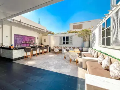 an outdoor patio with furniture and a bar at Luxurious 1 BR Apt Kempinski Central Avenue in Dubai