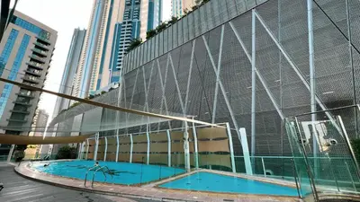 a building with two swimming pools in front of it at Damac Maison Mall Street! 2 Bedroom, 2 minute to Dubai Mall! in Dubai
