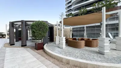 a building with a courtyard with plants in front of it at Damac Maison Mall Street! 2 Bedroom, 2 minute to Dubai Mall! in Dubai