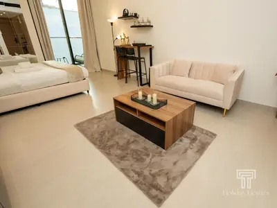 a living room with a couch and a coffee table at Brand New Luxe Studio Sauna, Gym&Pool With Access in Dubai