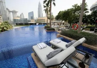 a swimming pool with lounge chairs in a city at Dubai Mall Luxury 1Bed The Address in Dubai