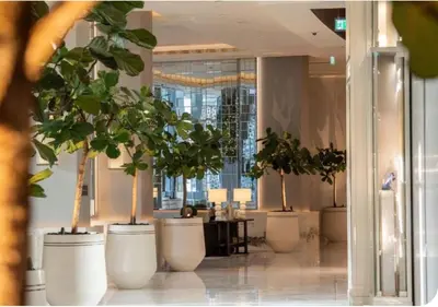 a row of potted plants in a lobby with a table at Dubai Mall Luxury 1Bed The Address in Dubai