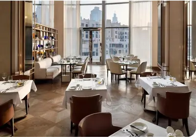 a restaurant with white tables and chairs and a large window at Dubai Mall Luxury 1Bed The Address in Dubai