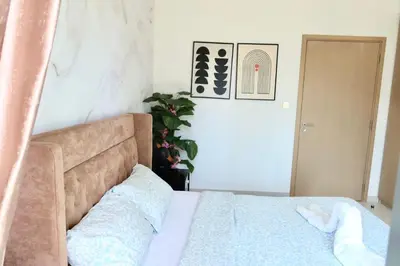 a bedroom with a bed with a blue comforter at Minteh Holiday Home in Dubai