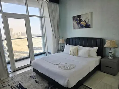 a bedroom with a large bed with a large window at Bayz by Danube by That Place Home Living in Dubai
