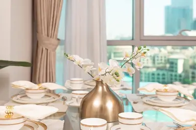 a table with a vase with flowers in it at Elite Royal Apartment - Full Burj Khalifa & New Fountain View - Panoramic - Luxurious - Magnus in Dubai