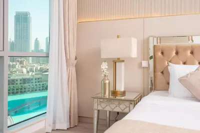 a bedroom with a bed and a window with a pool at Elite Royal Apartment - Full Burj Khalifa & New Fountain View - Panoramic - Luxurious - Magnus in Dubai