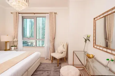a bedroom with a bed and a mirror and a chair at Elite Royal Apartment - Full Burj Khalifa & New Fountain View - Panoramic - Luxurious - Magnus in Dubai